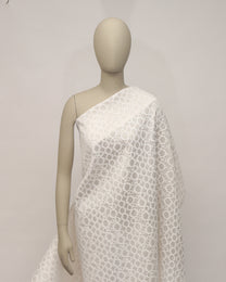 Mannequin wearing a white textured dress against a plain background
