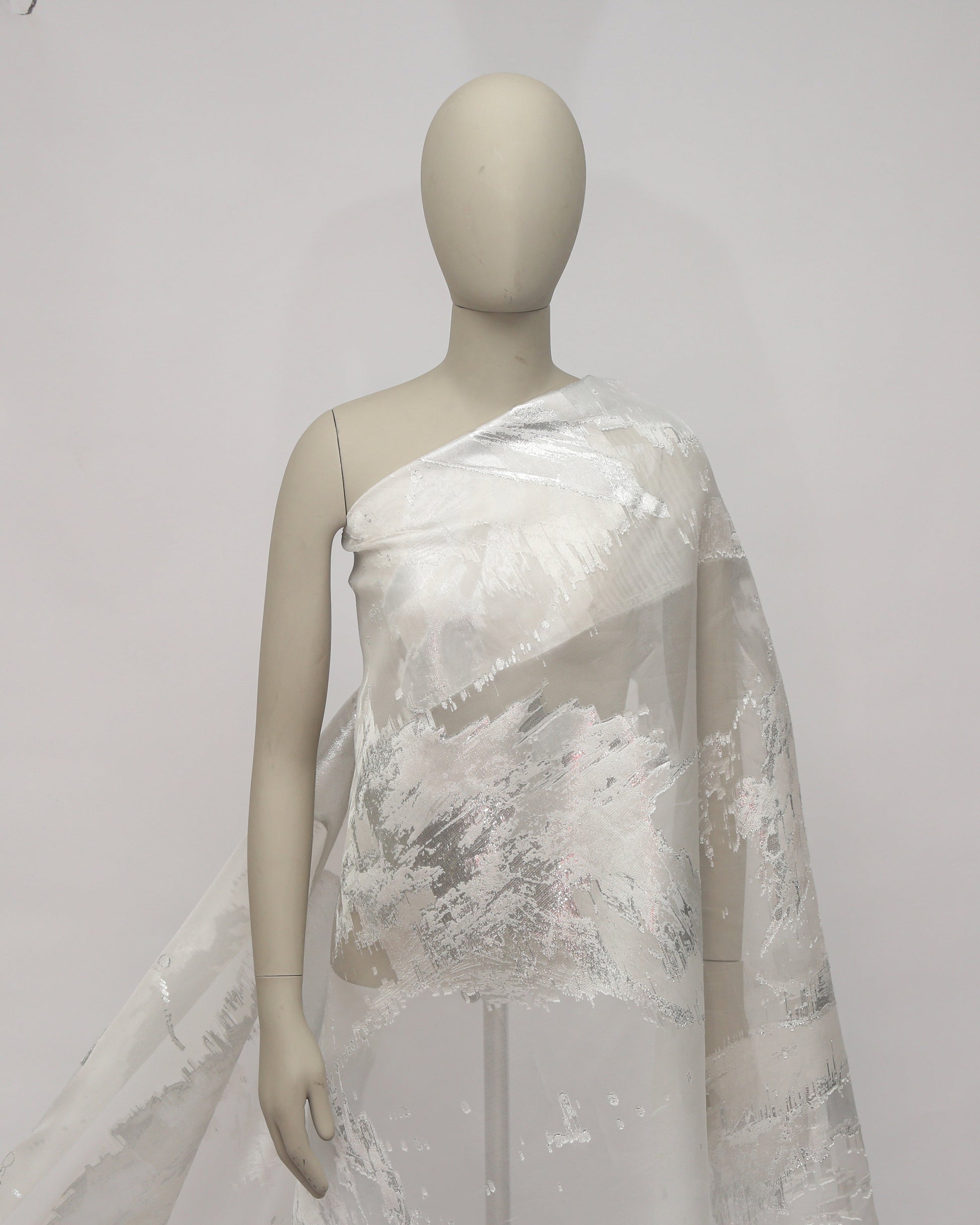 Mannequin wearing a white lace dress against a plain background