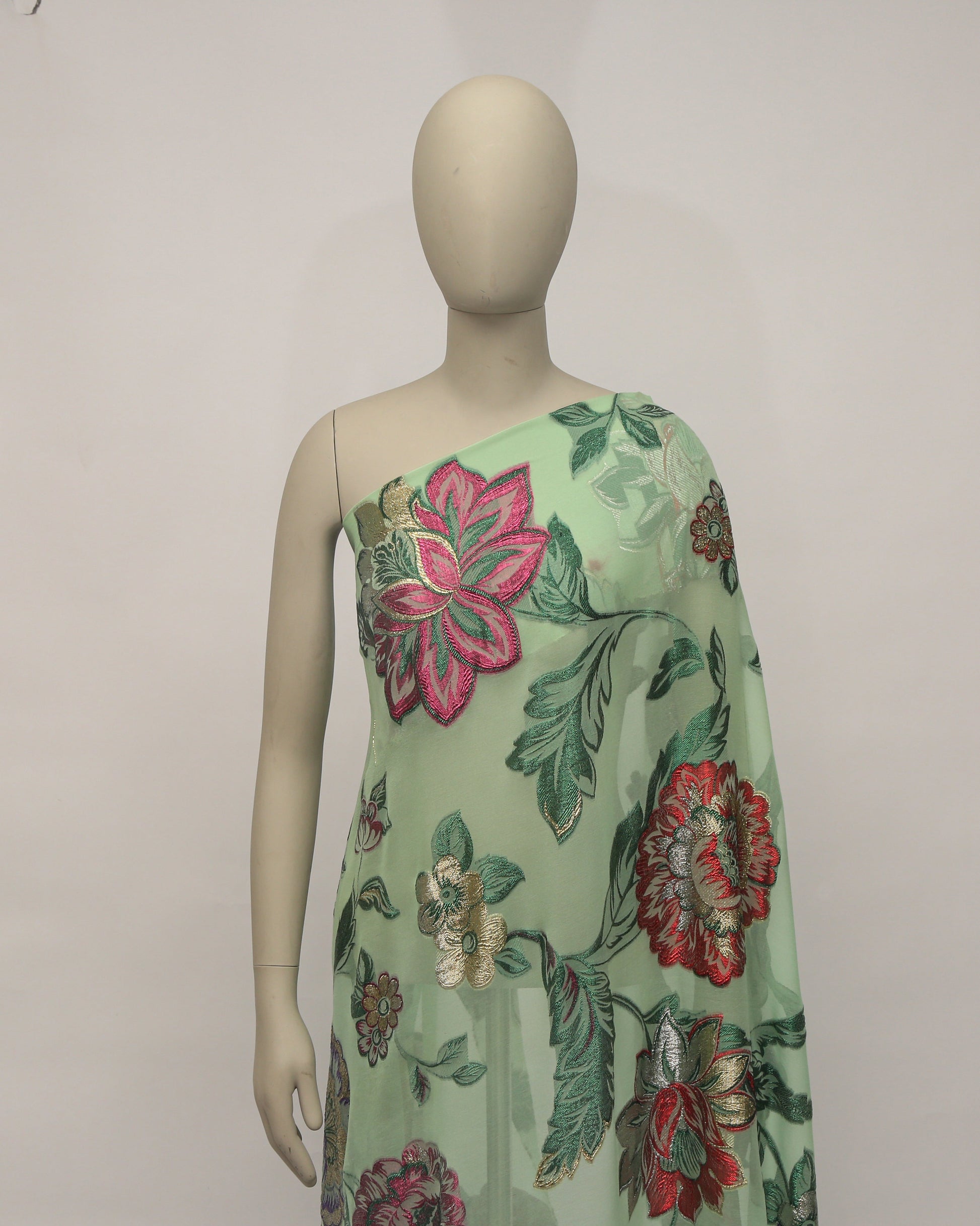Mannequin wearing a floral dress with a light green background